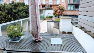 eine Außenterrasse mit einem Regenschirm und Topfpflanzen in der Unterkunft Central apartment with terrace in Knokke in Knokke-Heist