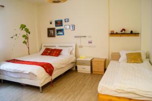 金湖鎮的住宿－叮叮單車民宿，一间卧室设有两张床和床头柜