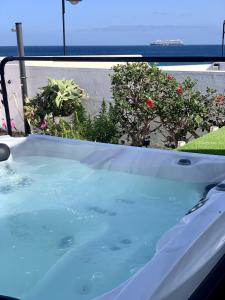 eine Whirlpool-Badewanne auf einem Balkon mit Blumen in der Unterkunft BUNGALOW BEACH&RELAX in Playa Honda