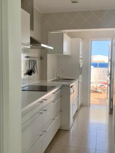 eine Küche mit weißen Schränken und Meerblick in der Unterkunft BUNGALOW BEACH&RELAX in Playa Honda