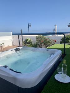vasca idromassaggio sull'erba con due bicchieri da vino di BUNGALOW BEACH&RELAX a Playa Honda