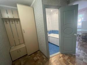 ein Badezimmer mit einer Tür und ein Badezimmer mit einer Badewanne in der Unterkunft 1-комнатная квартира в центре! in Petropawlowsk