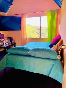 a bedroom with a bed with a window at El eden in Manizales