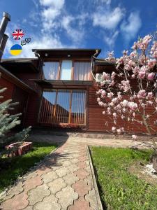 ein Haus mit einem blühenden Baum davor in der Unterkunft Ferienhaus 'Carolina' mit whirlpool, sauna und Grillplatz in Kossiw