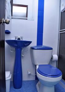 y baño con aseo y lavamanos azul. en Hotel Campestre El Triunfo en San Agustín