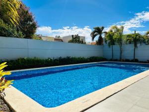 a swimming pool in front of a white fence at a 5 min de la playa alberca privada by G P S rentas in Mazatlán