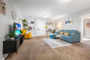 a living room with a blue couch and yellow chairs at Cozy and 3 mins to Tacoma dome. in Tacoma