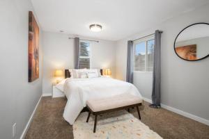 a white bedroom with a bed and a mirror at Cozy and 3 mins to Tacoma dome. in Tacoma