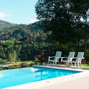 聖奧古斯丁的住宿－Hotel Campestre El Triunfo，一组椅子坐在游泳池旁