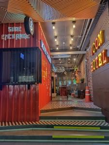 een winkelgevel met een rode muur en neonreclames bij Icon Hotel Hatyai in Hat Yai