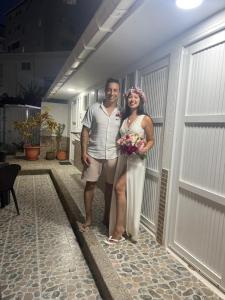 Un uomo e una donna in piedi davanti a un garage di Villa San Miguel a San Andrés