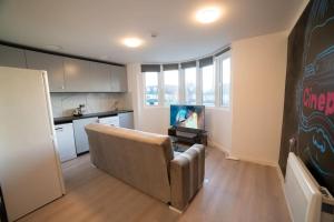 a living room with a couch and a tv at Spacious and Stylish 1 Bed Modern Flat in London