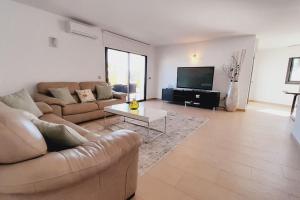 ein Wohnzimmer mit 2 Sofas und einem TV in der Unterkunft Villa Ca Sa Roca en Sant Josep de sa Talaia in San Jose de sa Talaia