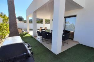 een patio met een tafel en stoelen en een boom bij Villa Ca Sa Roca en Sant Josep de sa Talaia in San Jose de sa Talaia