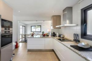 a kitchen with white cabinets and a counter top at Villa Ca Sa Roca en Sant Josep de sa Talaia in Sant Josep de Sa Talaia