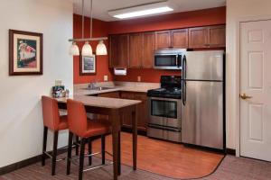 una cocina con armarios de madera y electrodomésticos de acero inoxidable en Residence Inn by Marriott Saratoga Springs, en Saratoga Springs