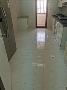 a kitchen with a white tiled floor and appliances at Cloud9 hostel in Dubai
