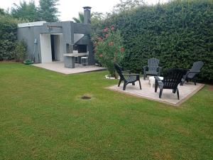 a group of black benches sitting in a yard at Portal La Delfina in Ciudad Lujan de Cuyo