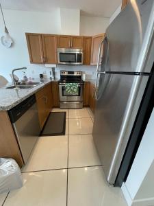 a small kitchen with a stainless steel refrigerator at Stay In The Okanagan - Copper Sky, West Kelowna in West Kelowna