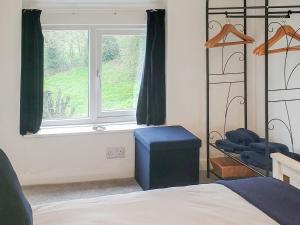 a bedroom with a bed and a window and a chair at Windmill Cottage in Little Eaton