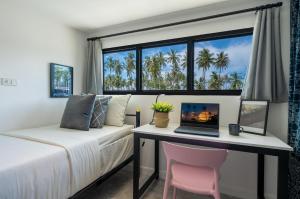 una camera da letto con un letto e una scrivania con un computer portatile di Manao Pool Villa 9 - 5 Mins Walk To The Beach a Ko Lanta
