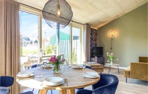 jadalnia ze stołem i krzesłami oraz dużym oknem w obiekcie Lovely Home In Oostwoud With Wifi w mieście Oostwoud