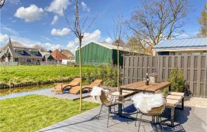 eine Terrasse mit einem Tisch, Stühlen und einem Zaun in der Unterkunft Lovely Home In Oostwoud With Wifi in Oostwoud