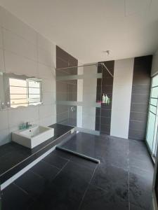 a large bathroom with a sink and a tub at Pro-Qaseh Room Stay , Darulaman Lake Home in Jitra