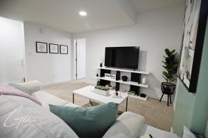 a living room with a couch and a flat screen tv at King Bed,Disney,Long Stays,Garage,Airport in Edmonton