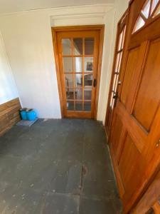 Habitación vacía con puerta de madera y suelo en Casa en sector residencial, en Arauco