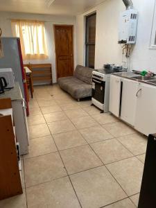 - une cuisine avec une cuisinière et un canapé dans la chambre dans l'établissement Casa en sector residencial, à Arauco