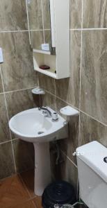 La salle de bains est pourvue d'un lavabo, d'un miroir et de toilettes. dans l'établissement RESIDENCIAL SIC, à Aimogasta
