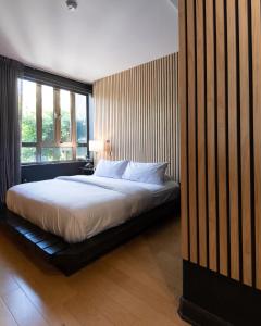 a bedroom with a bed and a large window at Audemar Boutique Hotel and Apartment Homes in Los Angeles