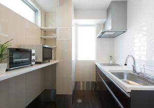 a kitchen with a sink and a microwave at Guesthouse La Cava women's single room / Vacation STAY 21865 in Yokohama