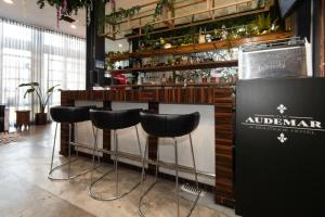 a bar with black stools in a restaurant at Audemar Boutique Hotel and Apartment Homes in Los Angeles