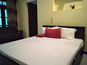 Una cama con dos almohadas rojas encima. en Sawanga Home Stay, en Weligama