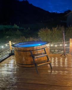 eine Holzbadewanne auf einer Terrasse mit einem Stuhl in der Unterkunft Hotel Rural SAN REMO in Santa Rosa de Cabal