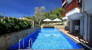 a large blue swimming pool next to a building at SUMMER OTEL in Muğla