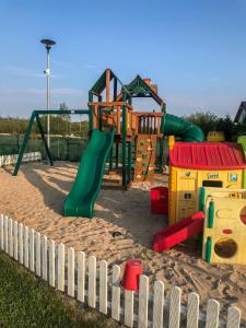 a playground in the sand next to a fence at Domki Filandia in Łazy