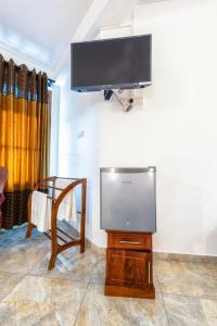 a flat screen tv sitting on a stand in a living room at Sol Y Mar - Unawatuna in Galle