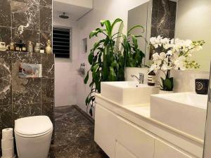 een badkamer met 2 wastafels, een toilet en een spiegel bij Chic Rose Bay Pad with HUGE outdoor sunny balcony in Sydney