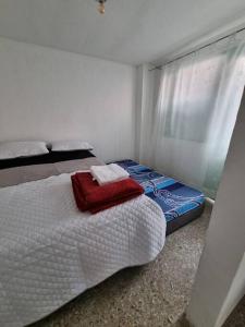 a bedroom with two beds and a window at Aparta estudio bonito, independiente bien ubicado in Bogotá