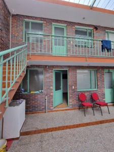 a brick building with two chairs and a balcony at Aparta estudio bonito, independiente bien ubicado in Bogotá