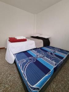 two beds sitting next to each other in a room at Aparta estudio bonito, independiente bien ubicado in Bogotá