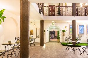 un hall avec des tables et des chaises ainsi qu'un escalier dans l'établissement Suites Experience by Hotel David, à Quito