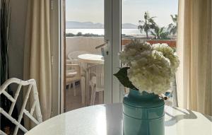 un vase rempli de fleurs blanches assises sur une table dans l'établissement Stunning Apartment In La Manga With Kitchenette, à La Manga del Mar Meno