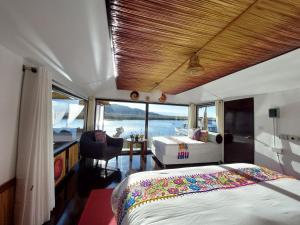 a bedroom with a bed and a desk on a boat at Uros Lodge Perú in Puno