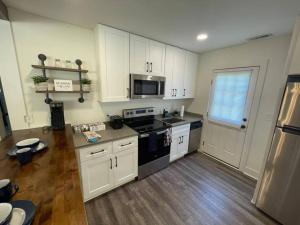 uma cozinha com armários brancos e um forno de fogão preto em Modern ~ Comfortable ~ Downtown, Queen beds, Bikes em Greenville