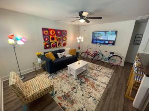 uma sala de estar com um sofá e uma televisão em Modern ~ Comfortable ~ Downtown, Queen beds, Bikes em Greenville