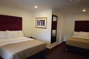 a hotel room with two beds and a mirror at The Hamlet Inn at Warwick in Warwick